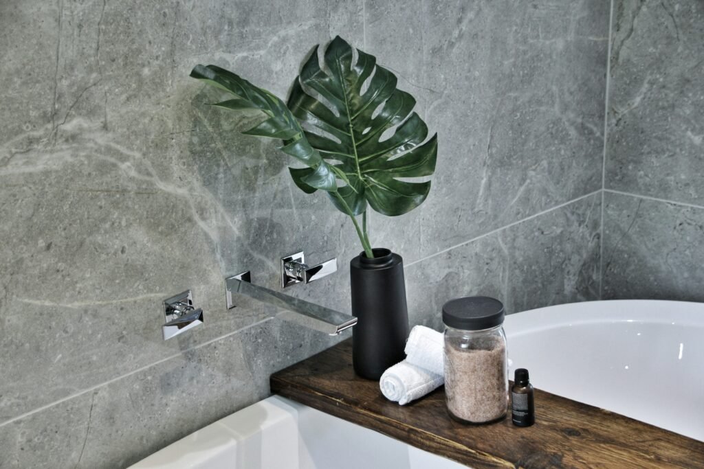Bathroom with bath products, towels and toiletries arranged beside the tub